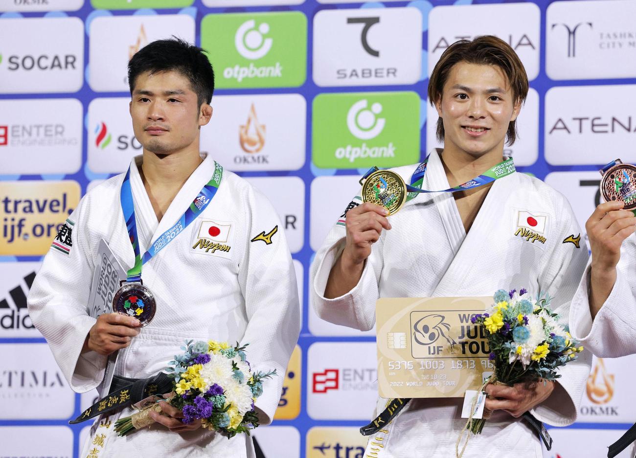 男子66キロ級で優勝し、金メダルを掲げる阿部一二三。左は2位の丸山城志郎（共同）