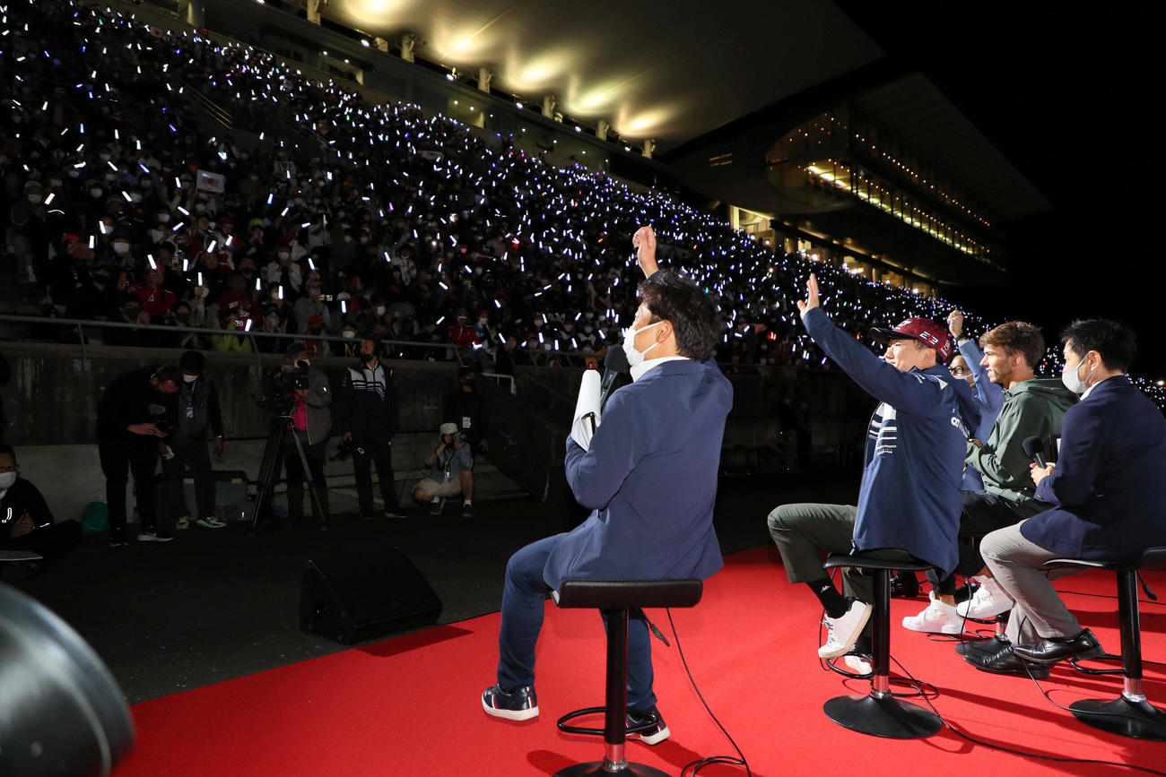 前夜祭でファンの点すペンライトに手を振る、アルファタウリの角田裕毅（左から2人目）とピエール・ガスリー（同3人目）（撮影・宮崎幸一）