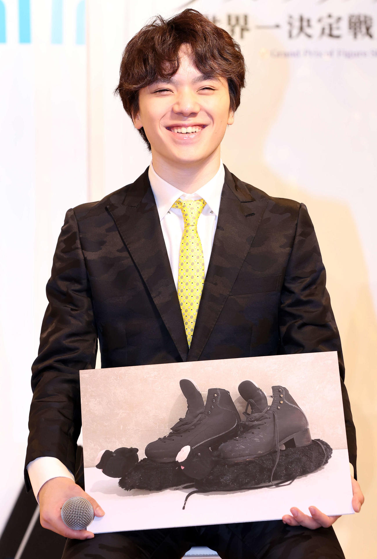フィギュアスケート「グランプリシリーズ／ファイナル2022」の記者会見で、相棒のスケート靴の写真を手に笑顔を見せる宇野（撮影・浅見桂子）