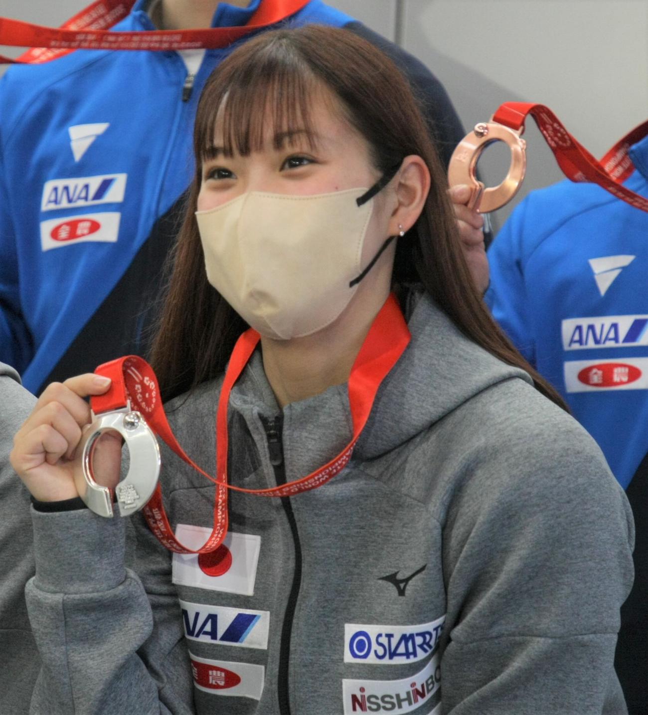 卓球の世界選手権女子団体で銀メダルを獲得し、帰国した成田空港で笑顔でメダルを手にする長崎（撮影・藤塚大輔）