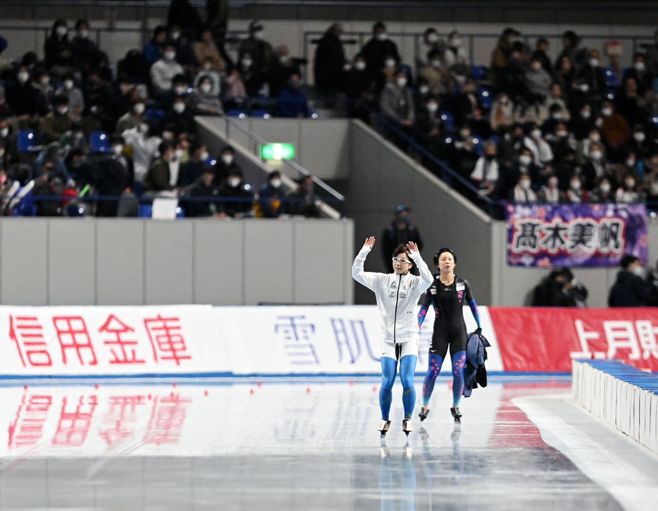 引退レースを終えた小平（左）は会場のファンに手を振る。右は高木（撮影・滝沢徹郎）