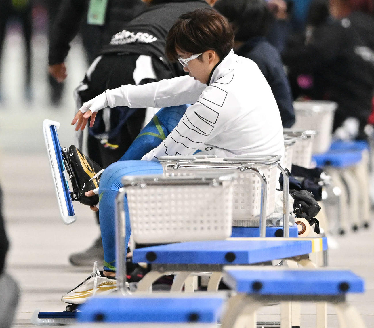 引退レースを終えスケート靴を脱ぐ小平（撮影・滝沢徹郎）