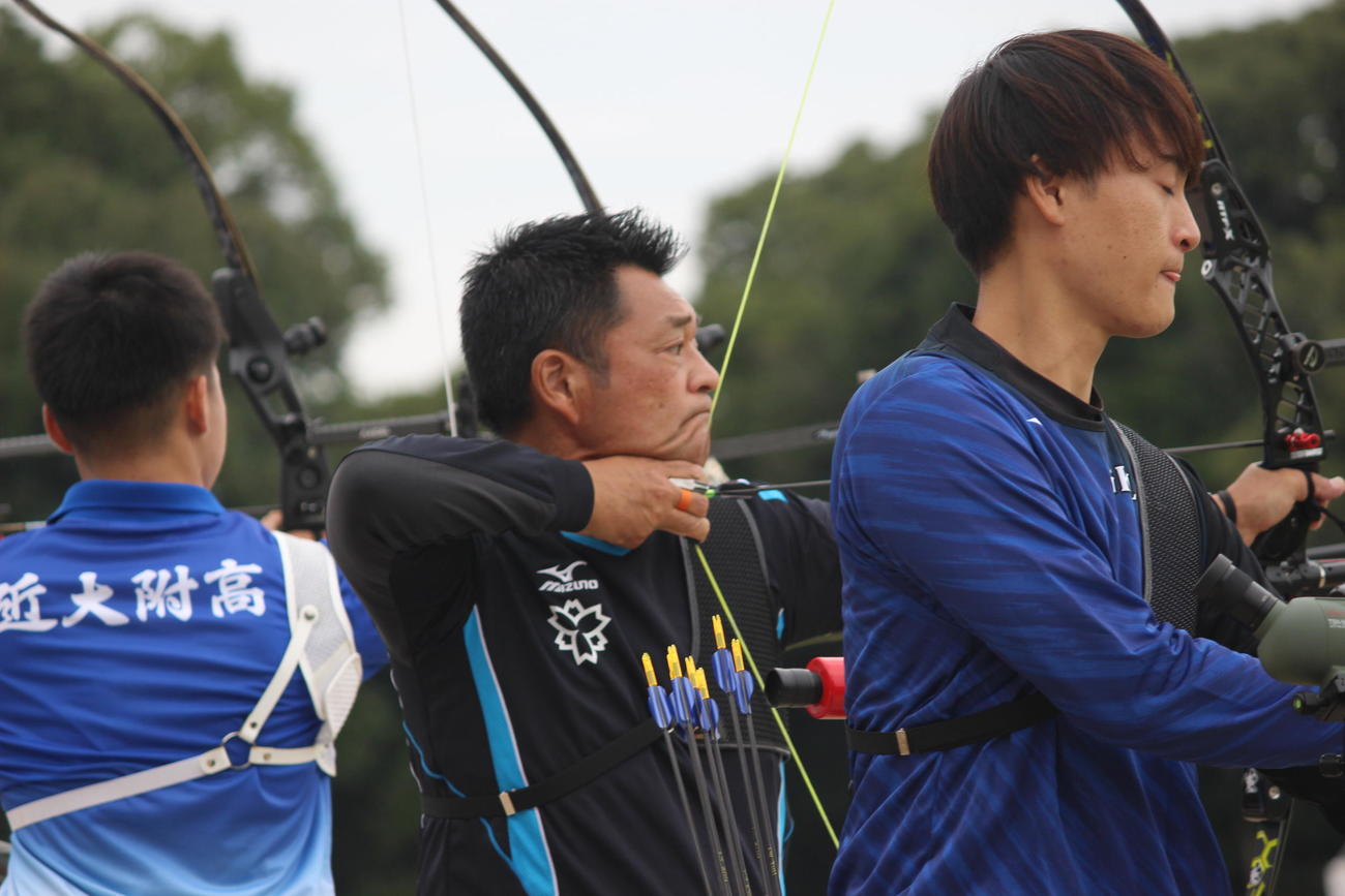 アーチェリー全日本選手権の予選ラウンドで若い選手らと競う山本博（中央）（撮影・首藤正徳）