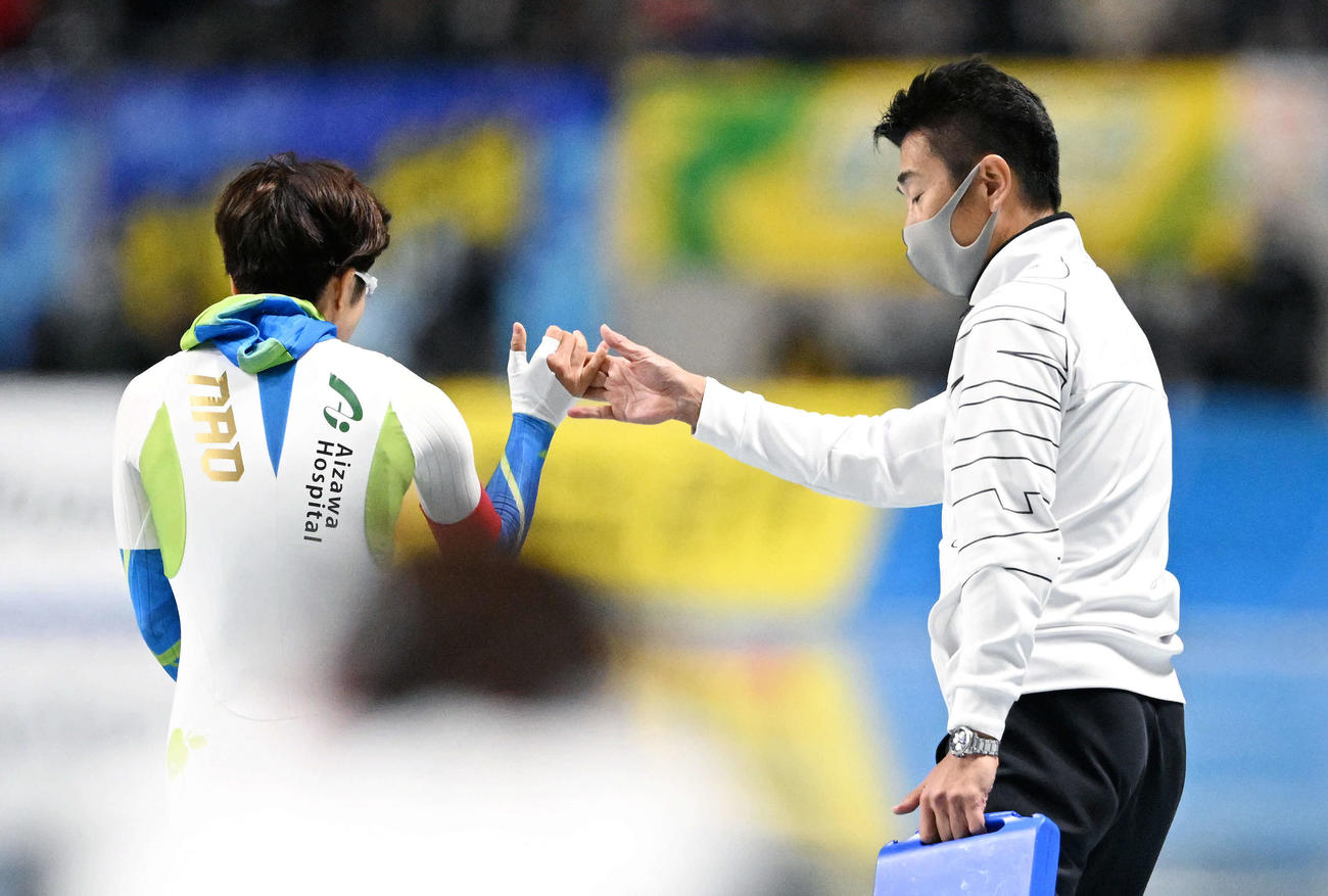 引退レースを終えた小平（左）とタッチを交わす結城コーチ（撮影・滝沢徹郎）