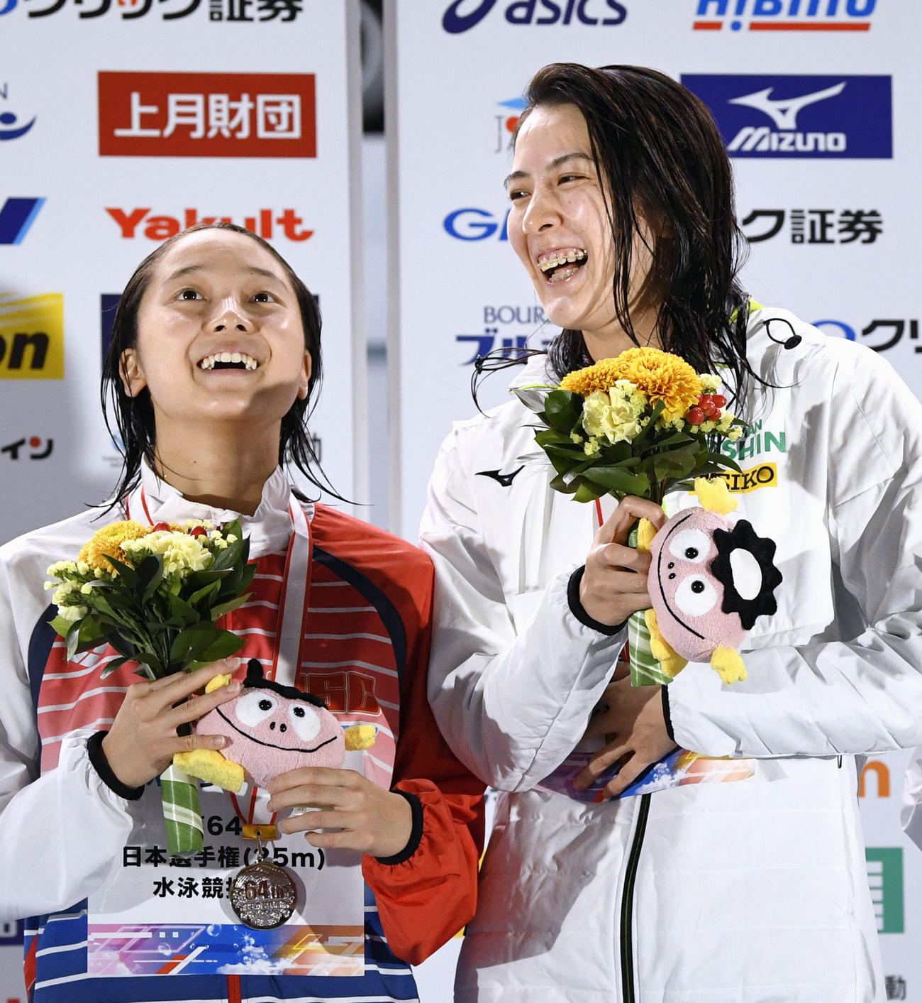 女子200 メートル 個人メドレーで優勝し、表彰台で笑顔の大橋悠依（右）。左は2位の成田実生（共同）