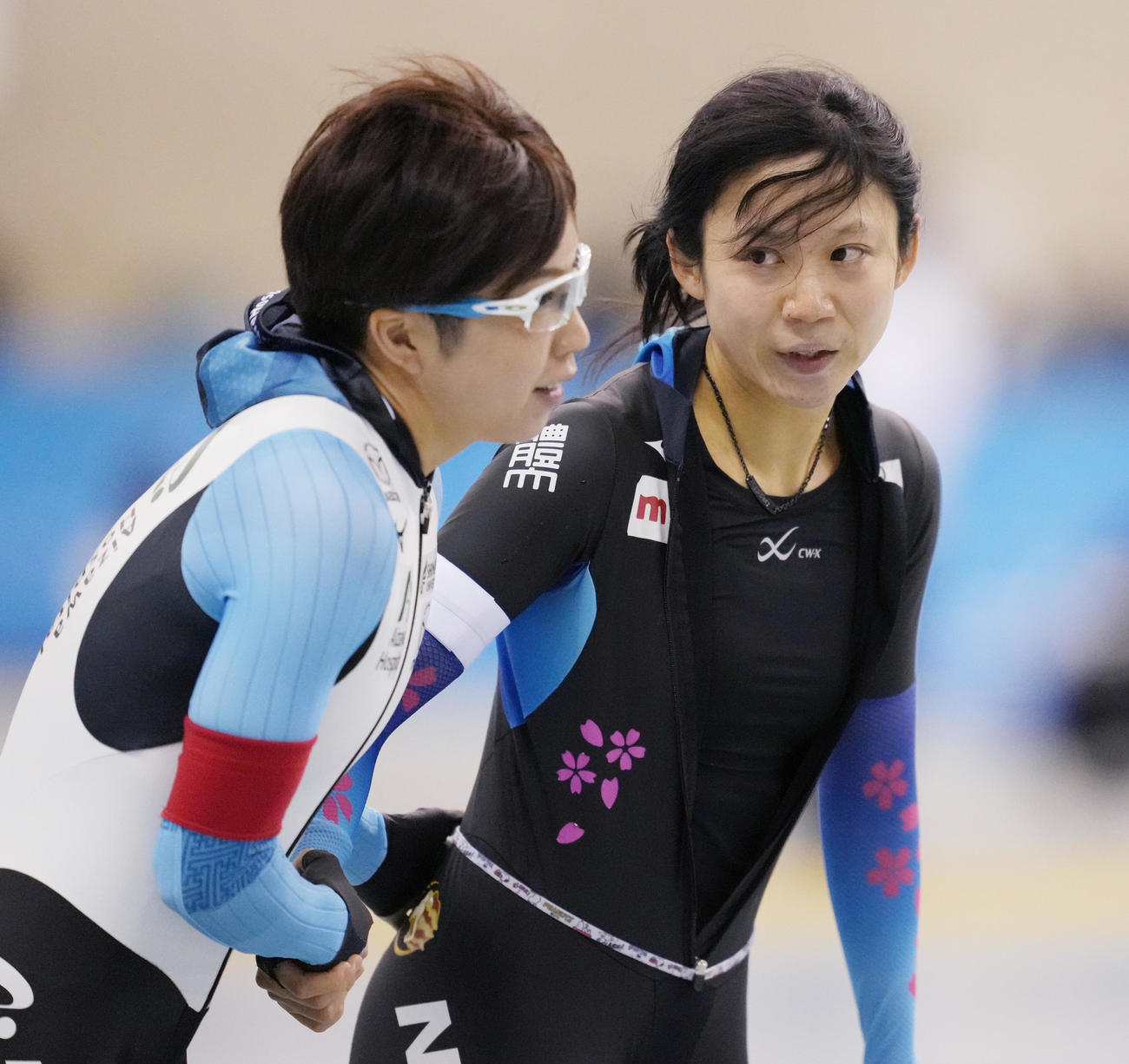 21年12月、女子1500メートルで優勝し、3位の小平奈緒（左）に握手で祝福される高木美帆