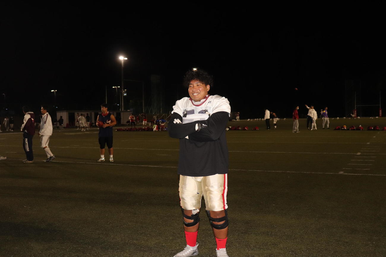 フィールドをバックに腕を組む立命大DL泉恭輔（撮影・竹本穂乃加）
