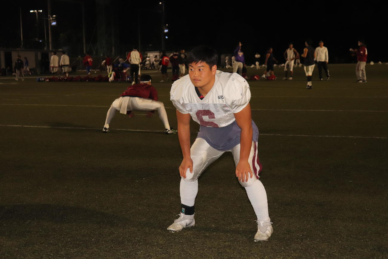 グラウンドで構えの姿勢を取る主将のLB坪倉拓未選手（撮影・竹本穂乃加）＝2022年10月26日、立命館大学びわこ・くさつキャンパス