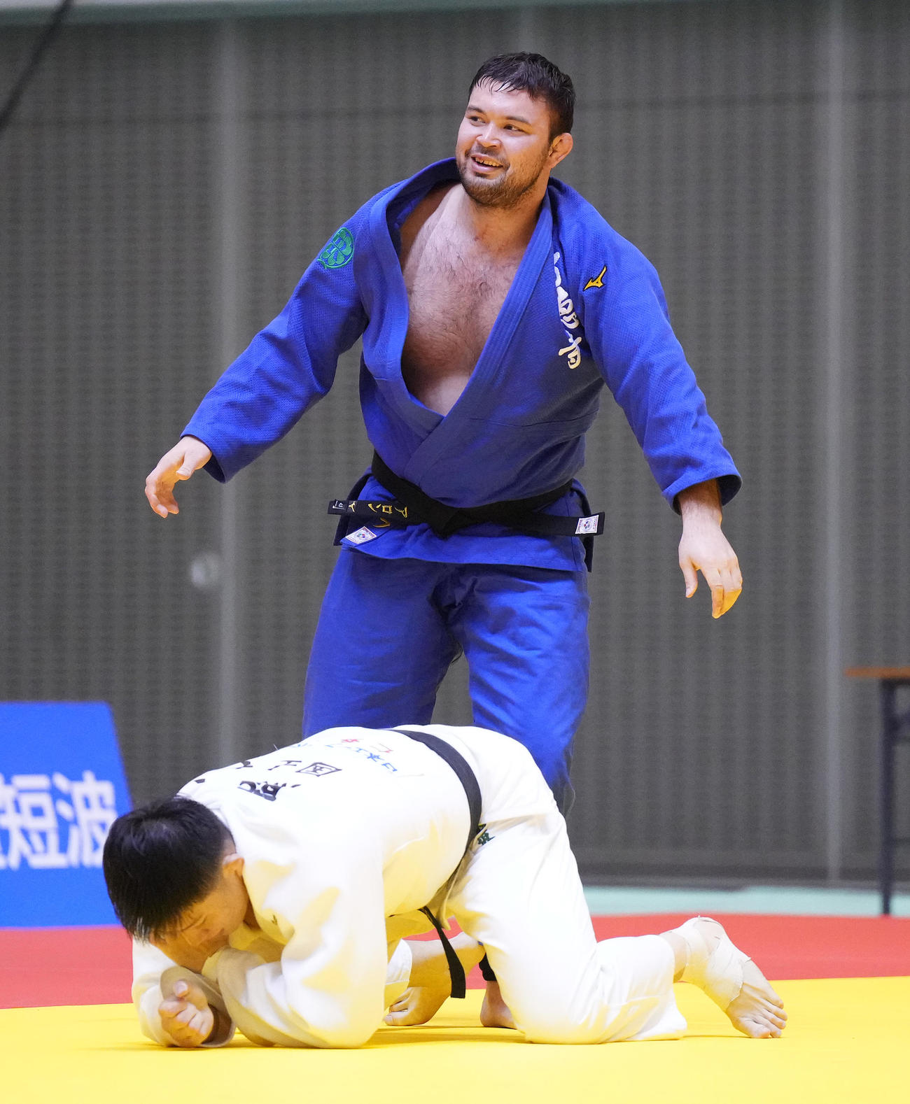 熊坂（下）との100キロ級3位決定戦で対戦中に笑みを浮かべるウルフ（撮影・菅敏）