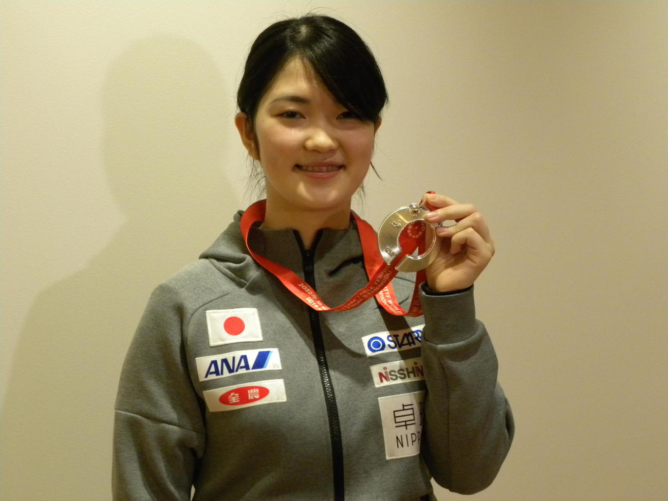 帰国した羽田空港で世界選手権団体戦の銀メダルを手に笑顔を見せる木原美悠（撮影・松本航）