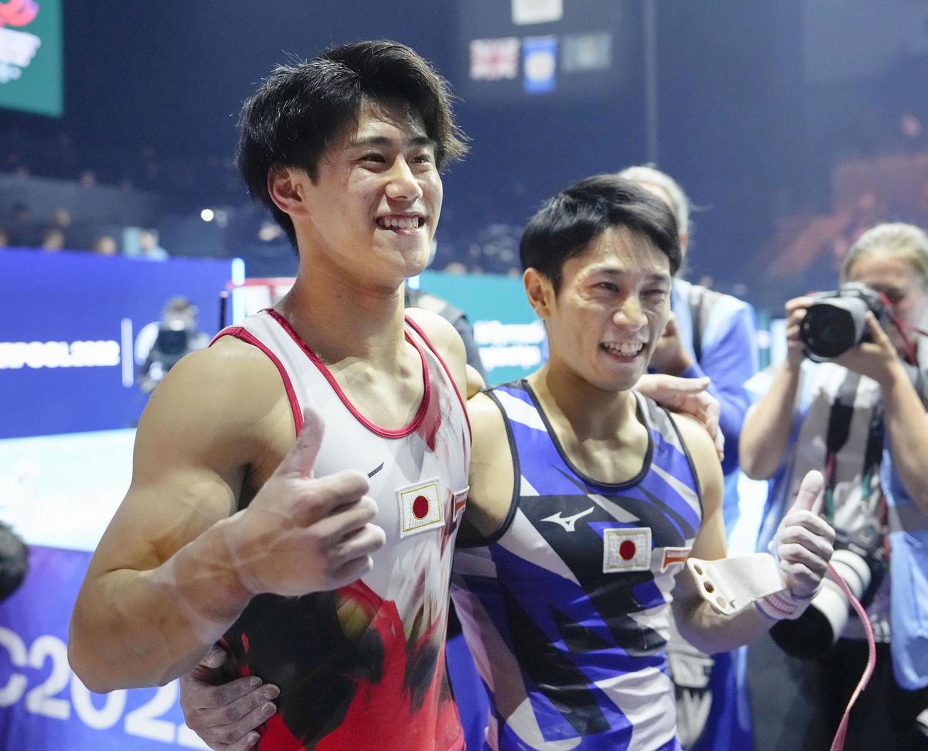 男子個人総合で初優勝し笑顔の橋本大輝（左）と、3位の谷川航＝リバプール（共同）