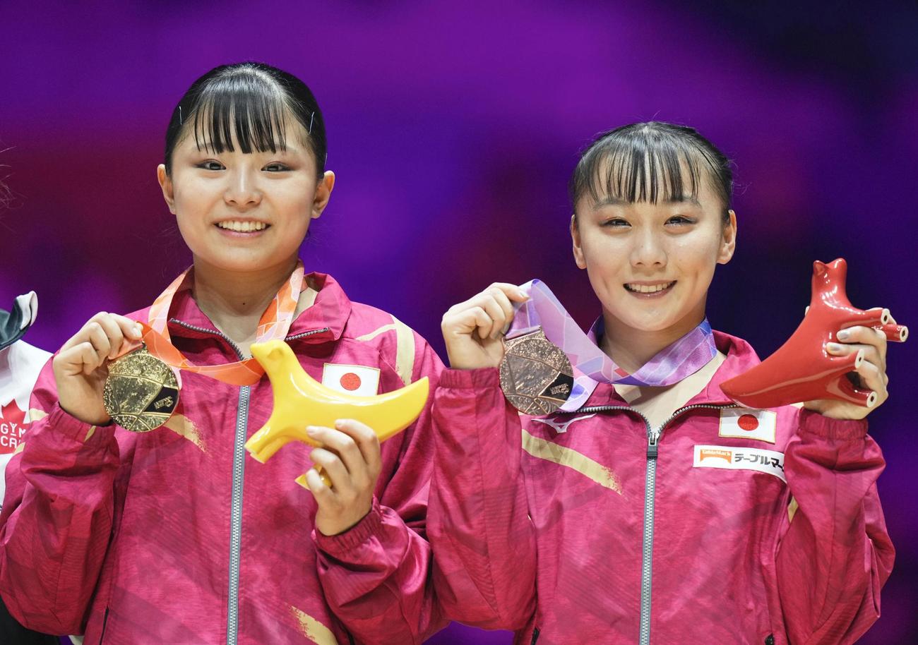 体操の世界選手権の女子平均台で獲得した金メダルを手にする渡部葉月（左）と銅メダルの宮田笙子（共同）