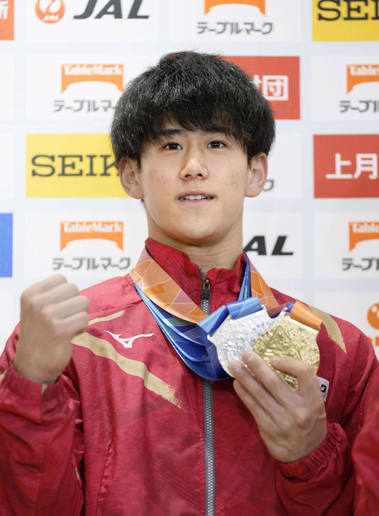 体操の世界選手権から帰国し、メダルを手にポーズをとる橋本大輝（共同）