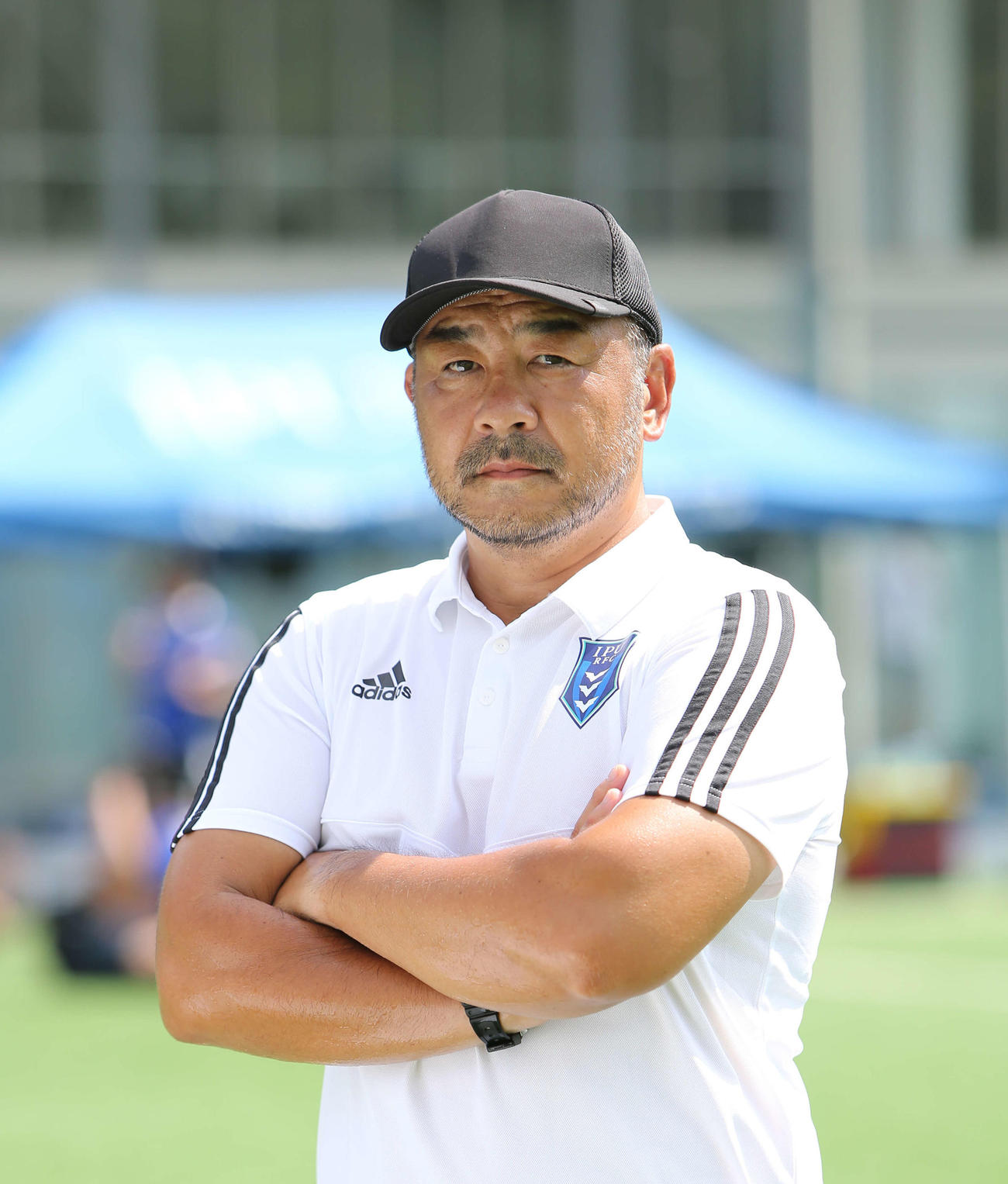 環太平洋大の小村監督は腕組みをし厳しい表情で選手を見つめる（環太平洋大学提供）　