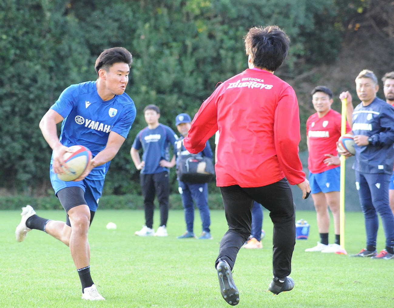 静岡ブルーレヴズの堀川ヘッドコーチ（右奥）は奥村（左）らBK陣の練習を見つめる