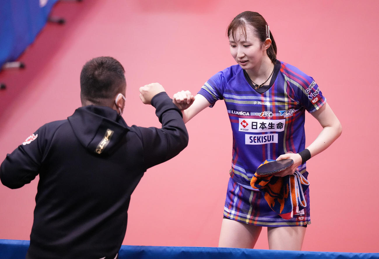 女子シングルス1回戦　1回戦を突破しタッチを交わす早田（撮影・鈴木みどり）