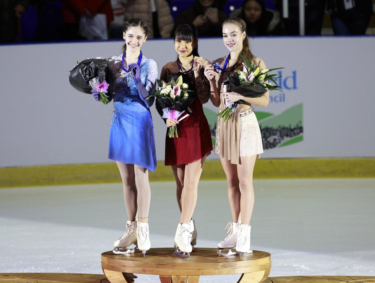 GP初優勝を飾り、金メダルを見せる三原舞依。左は2位のレビト、右は3位のグバノワ（ロイター）