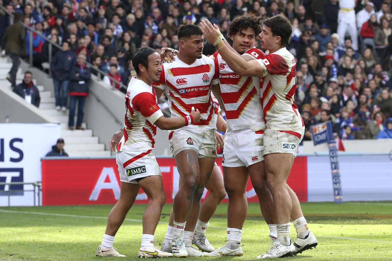 トライを決めたフィフィタを祝福する日本代表の選手たち（AP）
