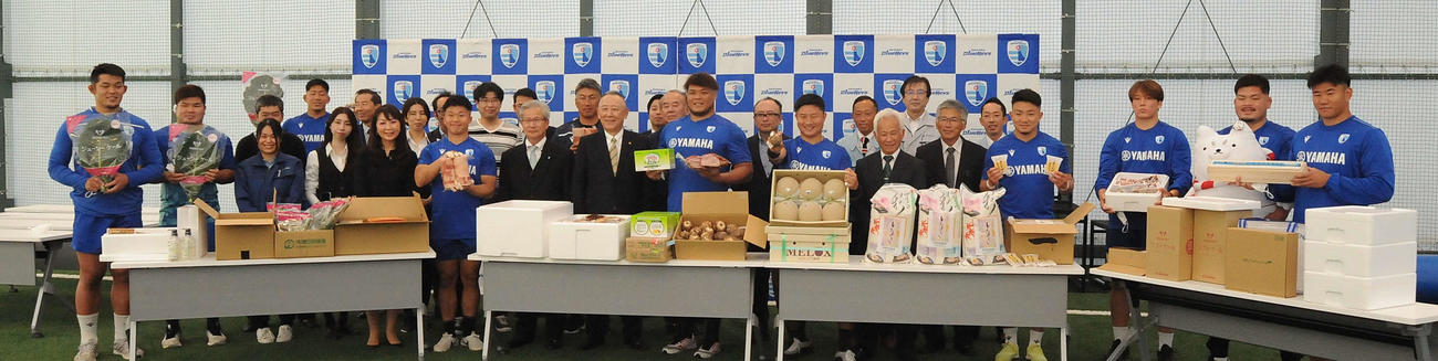 激励品を前に磐田商工会議所の関係者と記念撮影する静岡ブルーレヴズの選手ら
