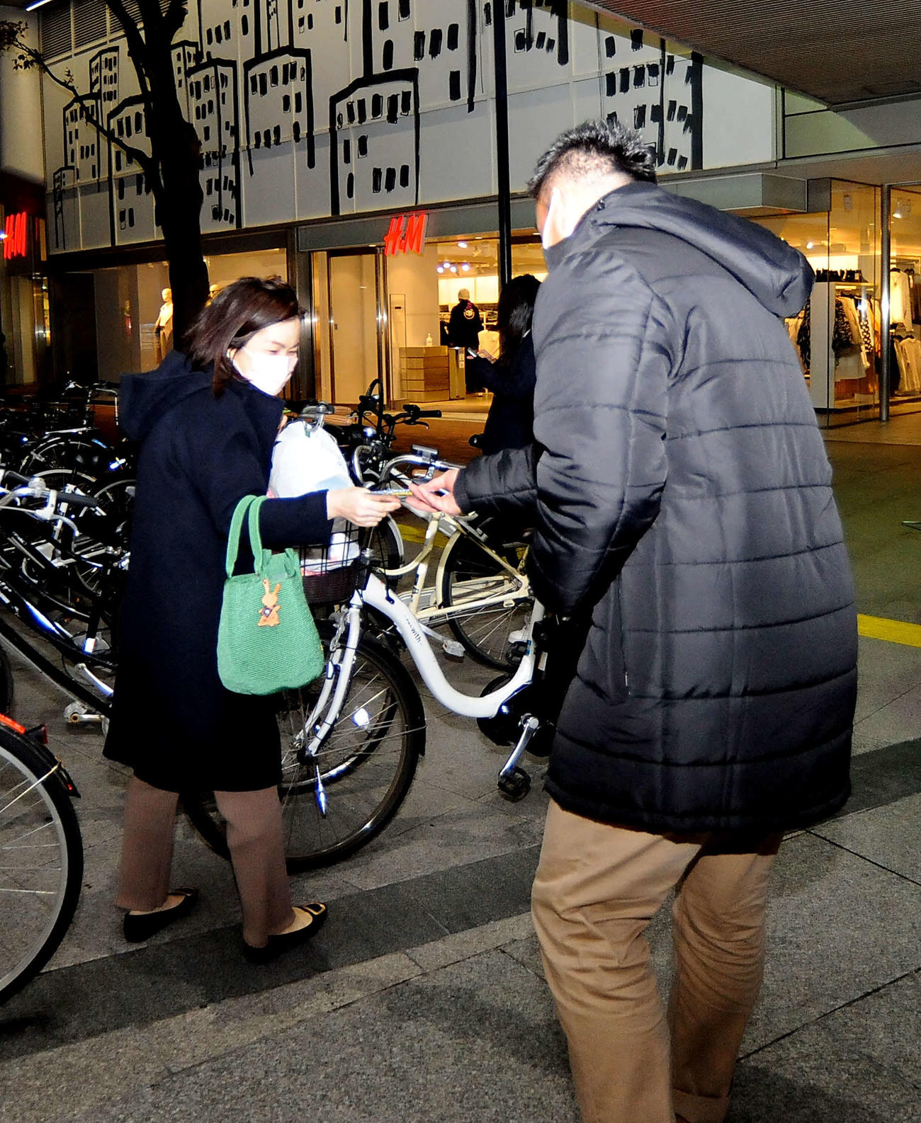 宣伝用の使い捨てカイロを通行人に配る静岡ブルーレヴズの五郎丸CRO（右）
