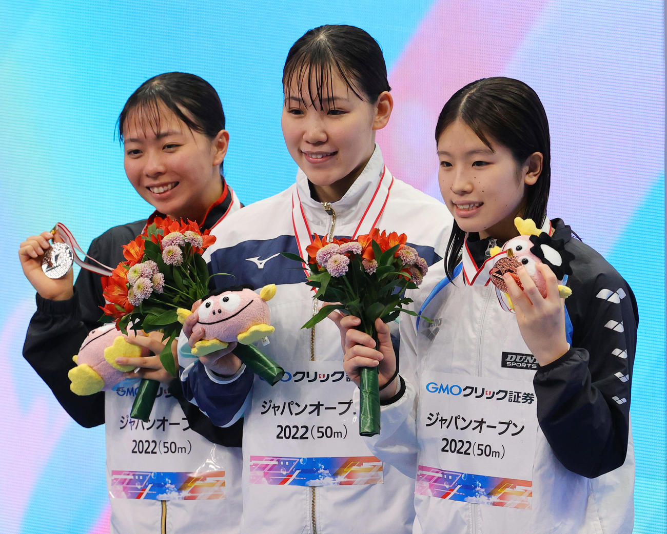 女子100メートル背泳ぎで優勝した白井（中央）は表彰台で2位の秀野（左）、3位の山本と笑顔（撮影・野上伸悟）