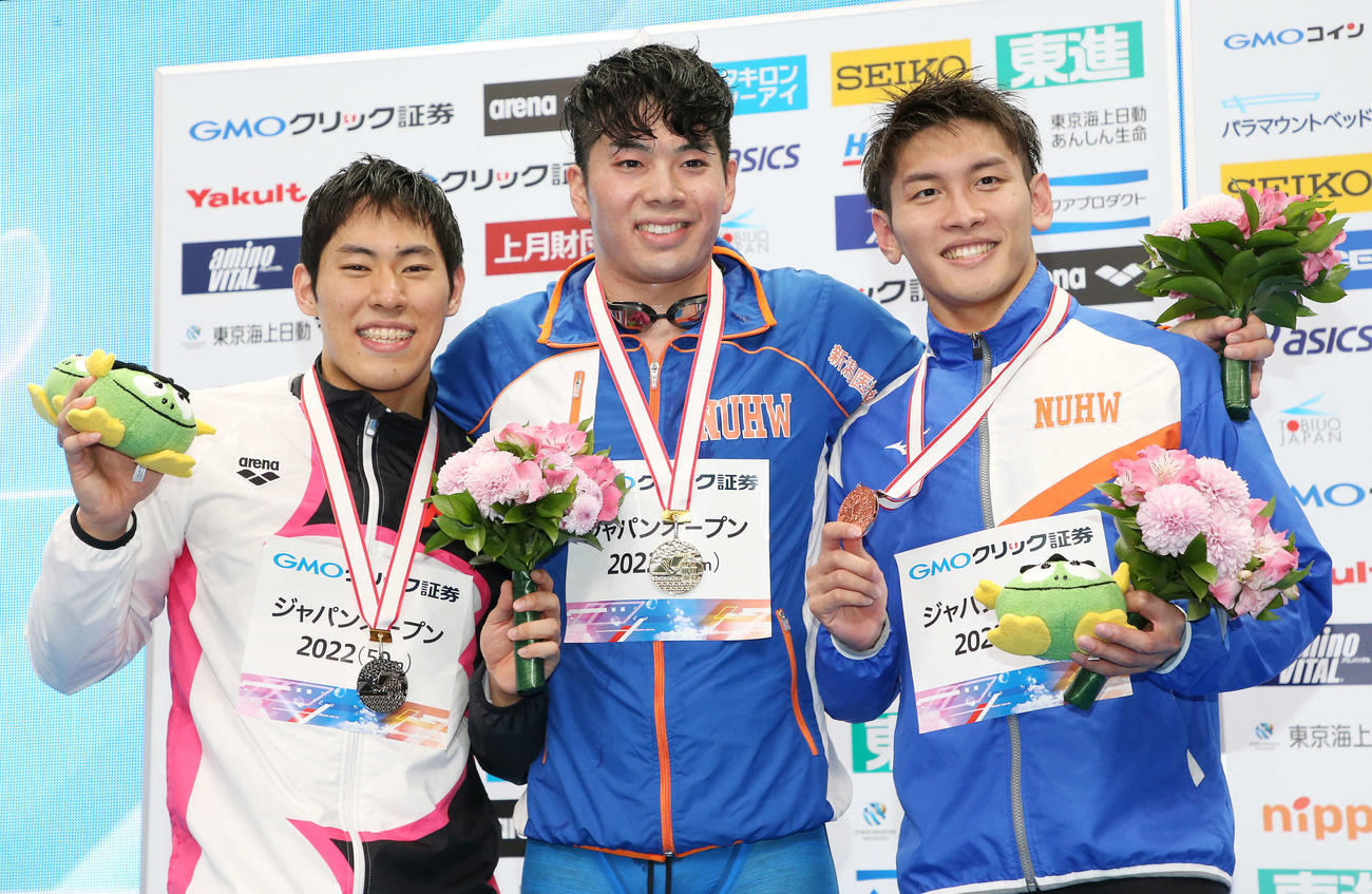 男子100メートルバタフライ決勝で優勝した水沼（中央）は、2位の本多（左）、3位の田中と表彰台で笑顔（撮影・宮地輝）