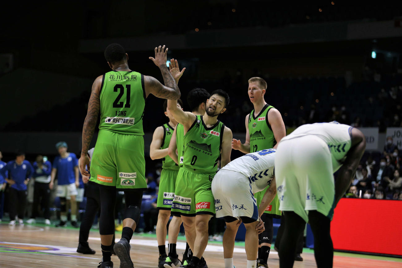 レバンガ北海道の橋本（中央）は、4戦ぶりの勝利を挙げ、ホッとした表情でショーン・ロングとハイタッチ（撮影・中島洋尚）　