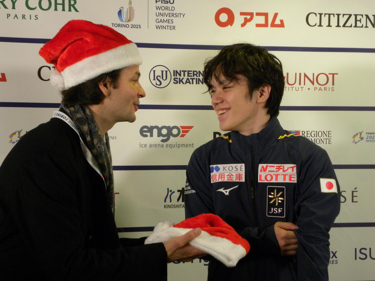 男子初優勝を飾った宇野昌磨（右）にサンタクロースの帽子を手渡すステファン・ランビエル・コーチ（撮影・松本航）