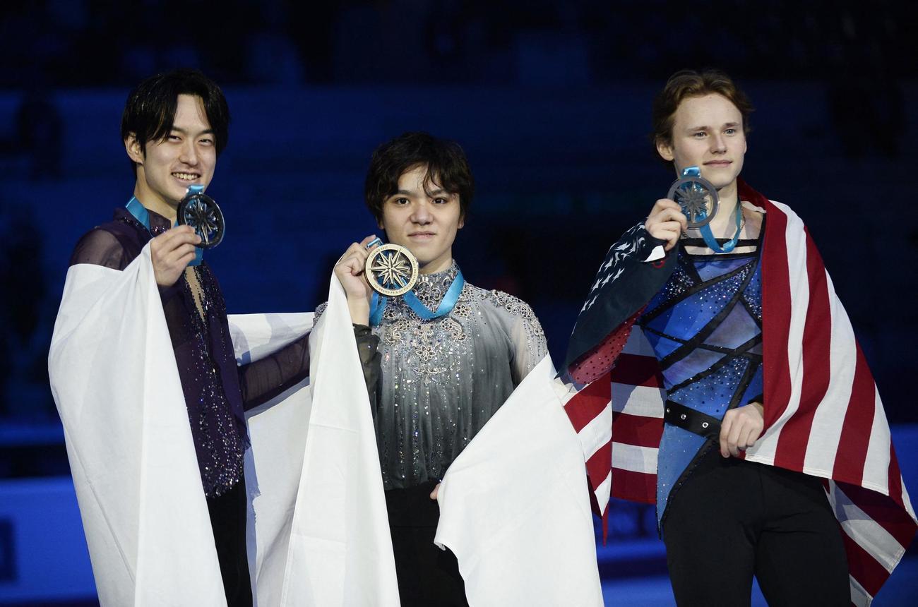 表彰式で国旗をまとい記念撮影する宇野昌磨（中央）、山本草太（左）、イリア・マリニン（ロイター）
