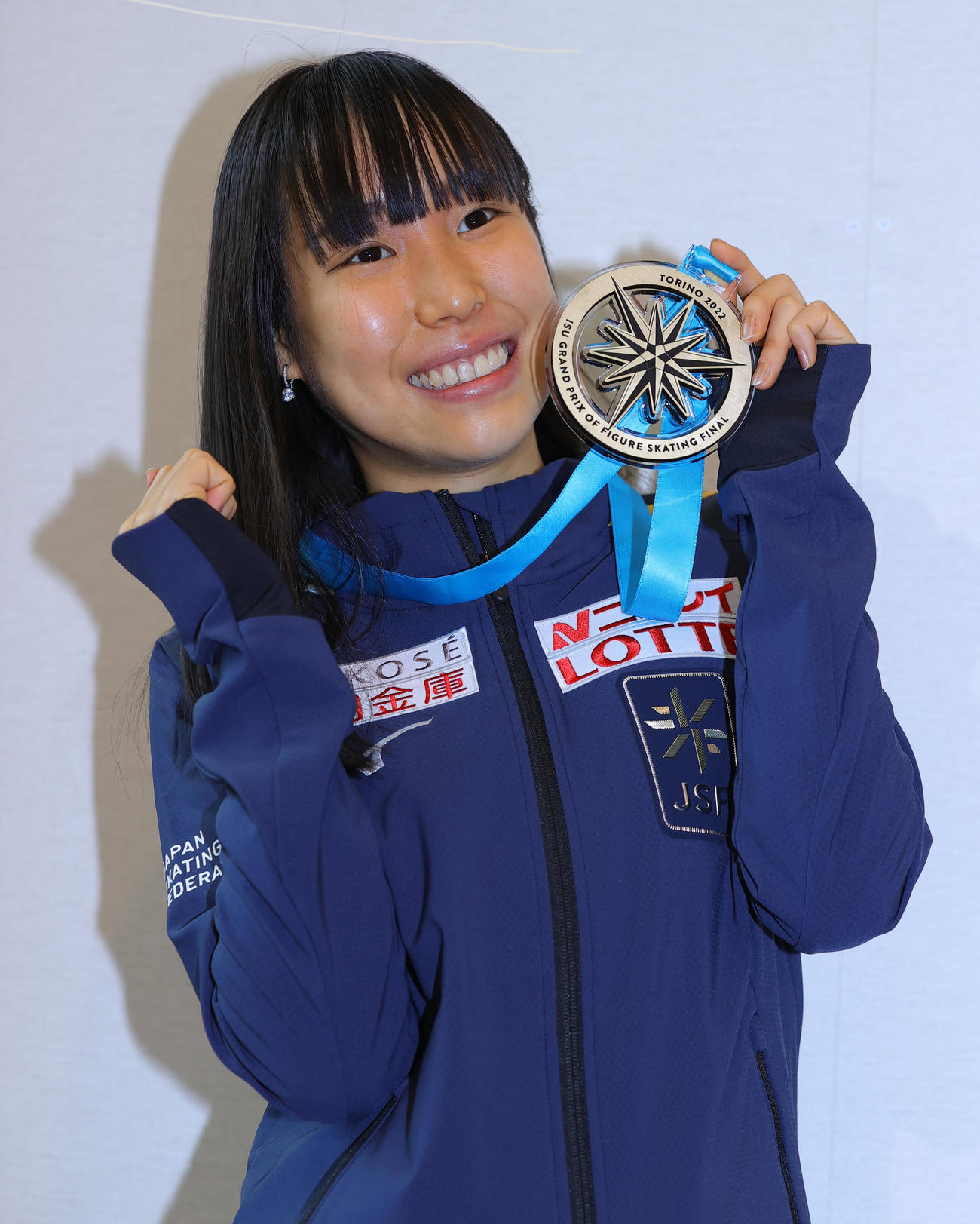 フィギュアスケートのグランプリファイナルで初優勝した三原舞依は、帰国した羽田空港で金メダルを手に笑顔（撮影・野上伸悟）