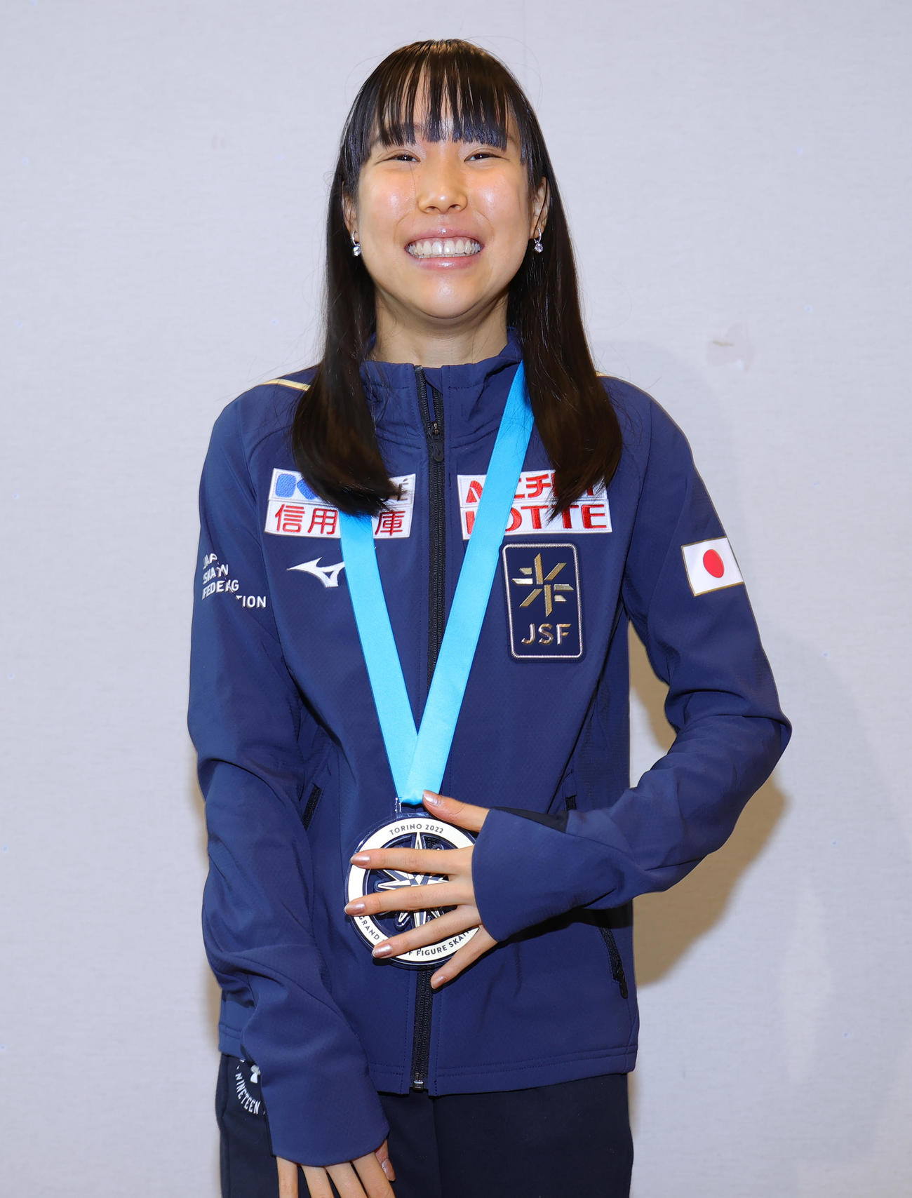フィギュアスケートのグランプリファイナルで初優勝した三原舞依は、帰国した羽田空港で金メダルを手に笑顔（撮影・野上伸悟）