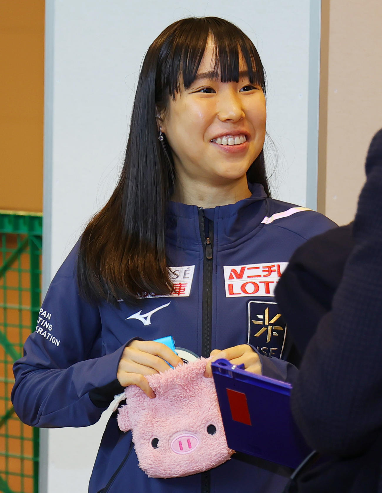 フィギュアスケートのグランプリファイナルで初優勝した三原舞依は、帰国した羽田空港での会見を終え、ピンクのブタさんポーチに金メダルをしまう（撮影・野上伸悟）