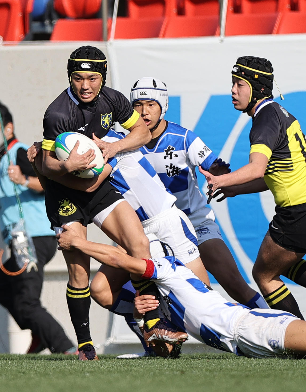 仙台育英対東海大静岡翔洋　前半、タックルを受けながら球をキープする仙台育英FB坂本（左）（撮影・上山淳一）