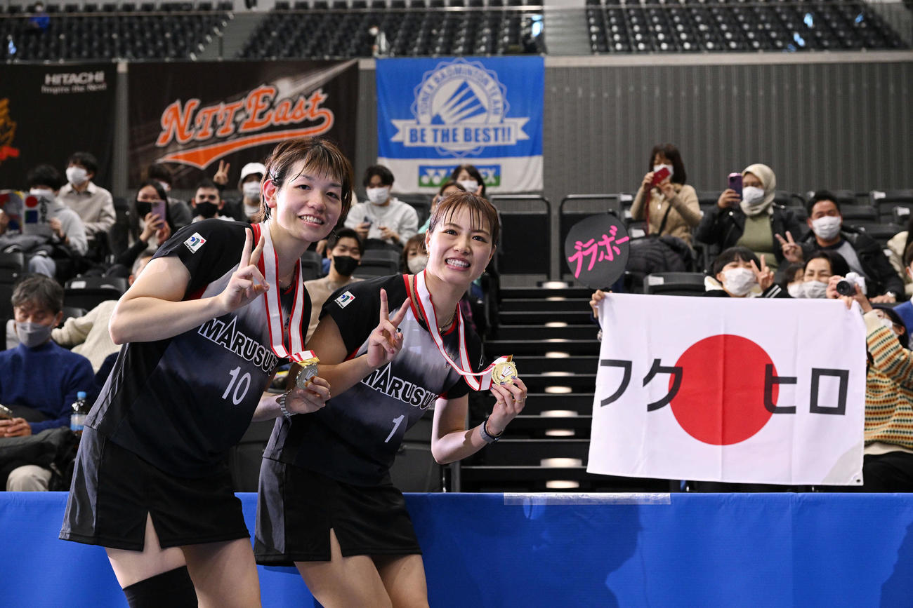 女子ダブルスで優勝を決め「フクヒロ」の旗と記念撮影する広田（左）と福島（撮影・滝沢徹郎）