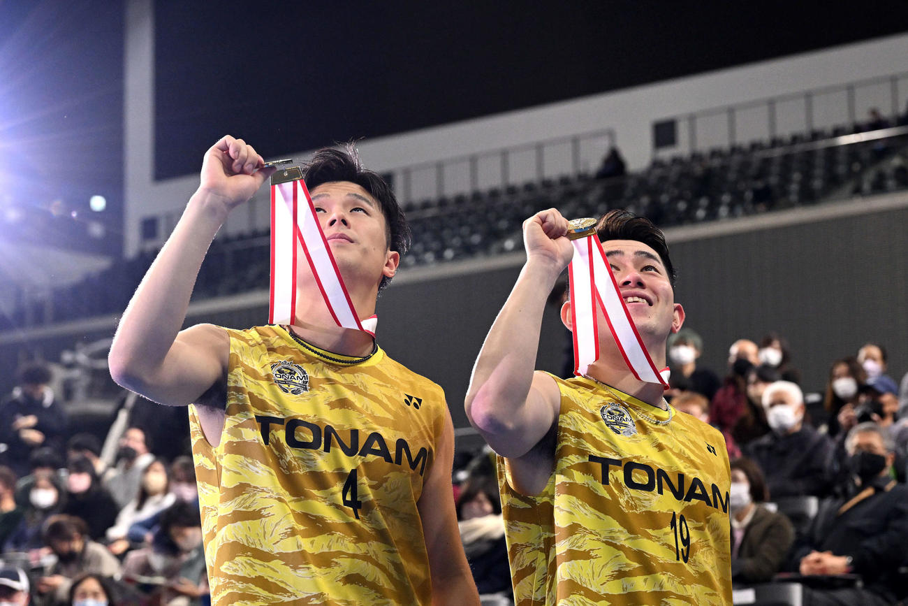 亡くなった綿貫勝介トナミHD社長に向けて男子ダブルスの優勝メダルを天へ掲げる小林（左）と保木（撮影・滝沢徹郎）