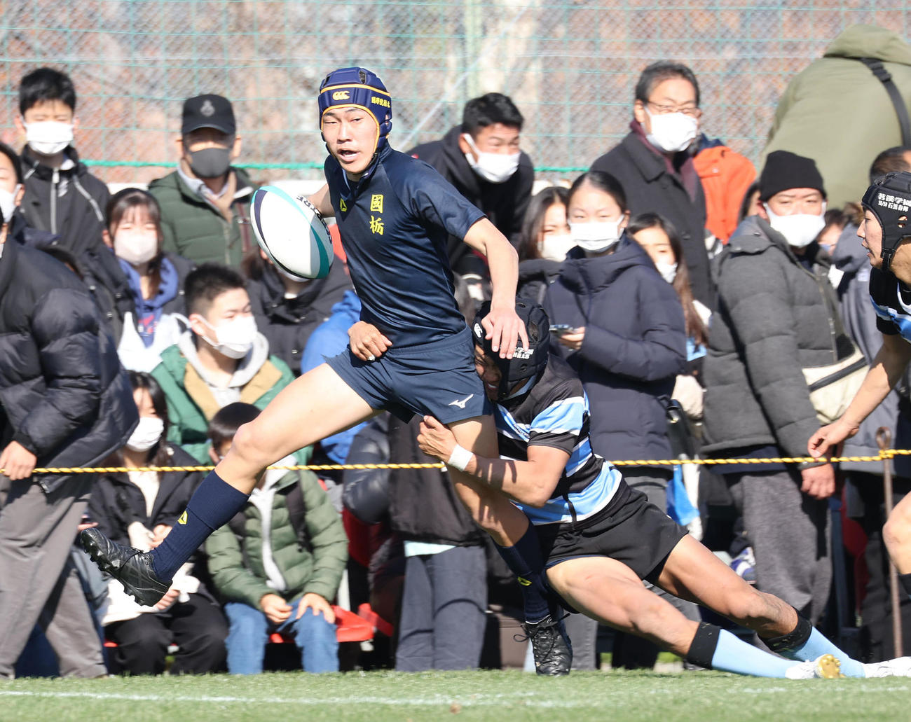 前半、タックルを受けながらも突進する国学院栃木WTB大友（撮影・白石智彦）