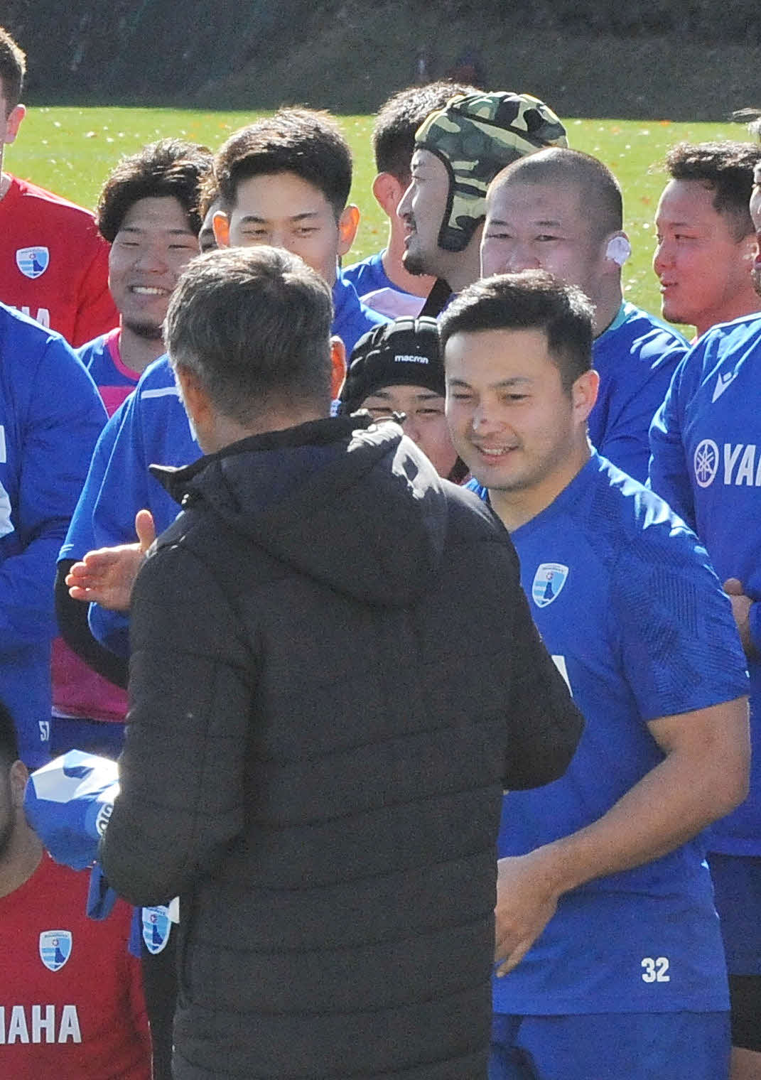堀川ヘッドコーチ（手前左）から試合用ジャージーを受け取る白井（同右）