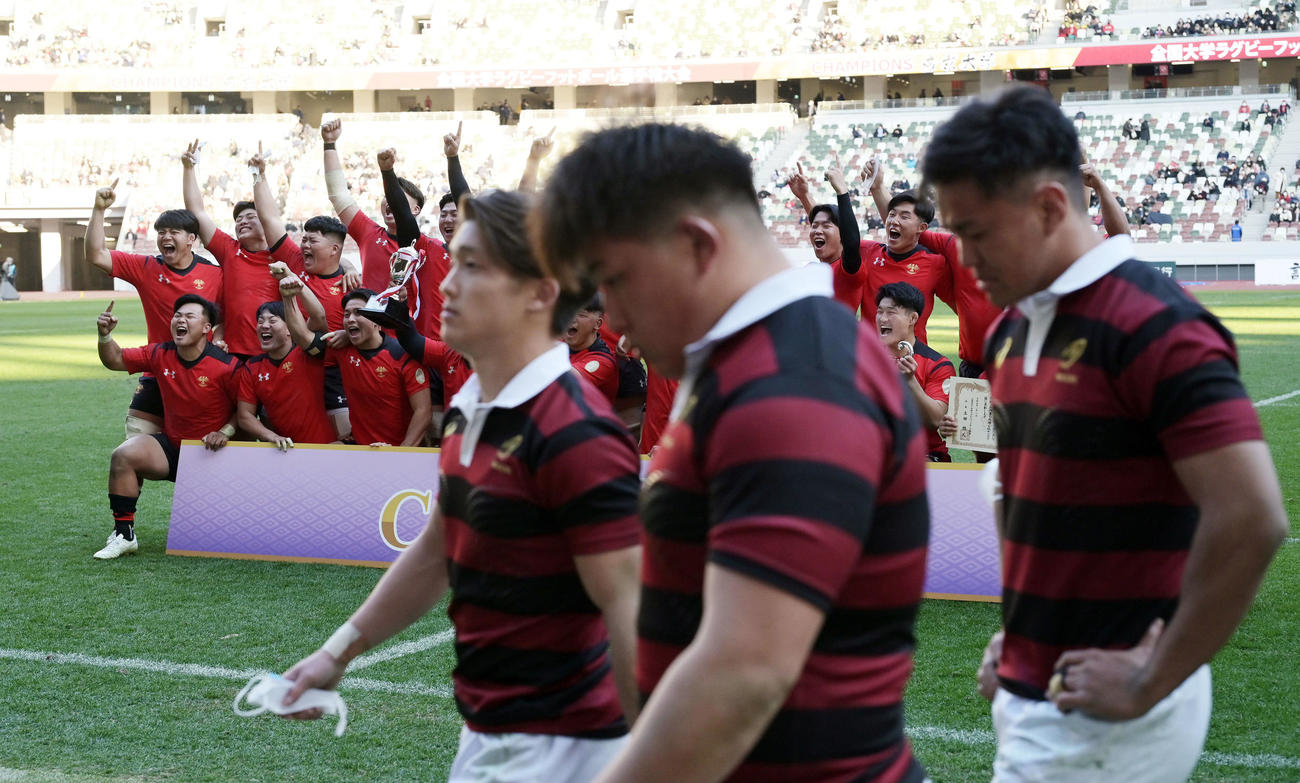 帝京大対早大　優勝の記念撮影をする帝京大の選手たちを横目に引き揚げる早大の選手たち（撮影・滝沢徹郎）