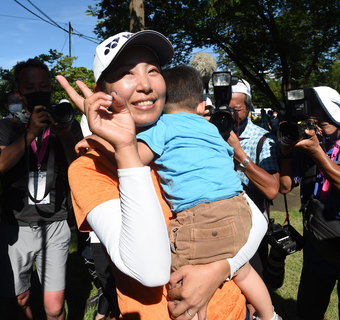 優勝した若林舞衣子は寝ている長男龍之介君を抱いてVサインする（2021年7月撮影）