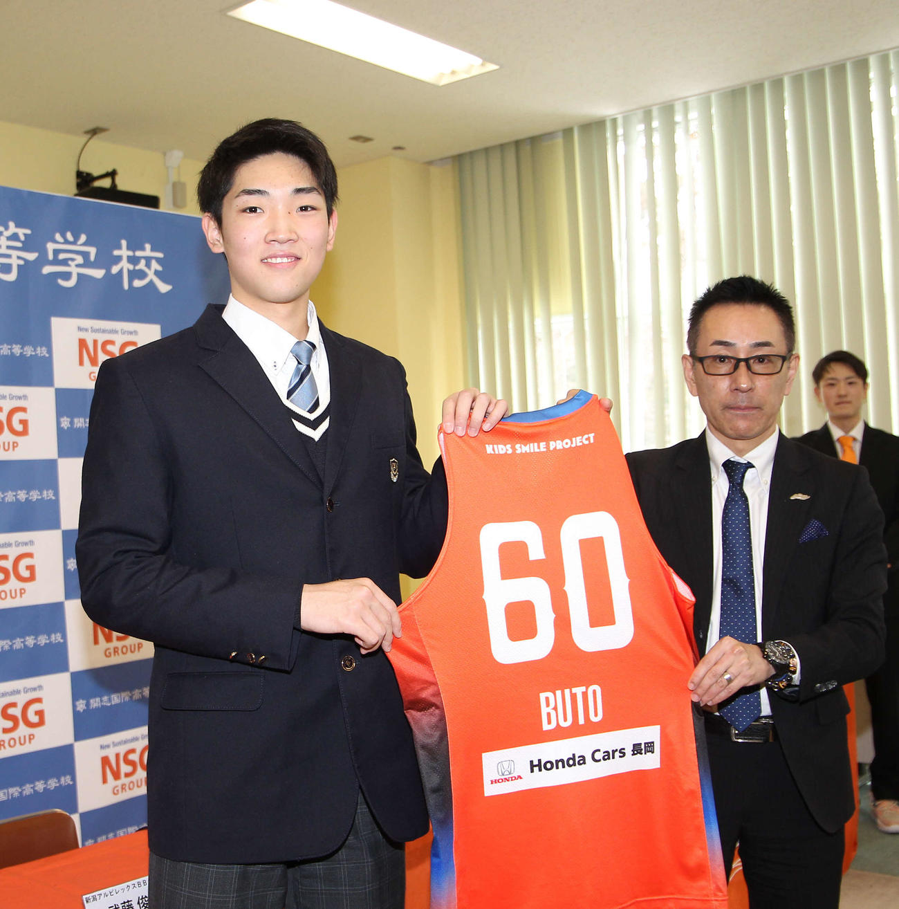 武藤は新潟の川上社長から背番号60のユニホームを手渡されてニッコリ