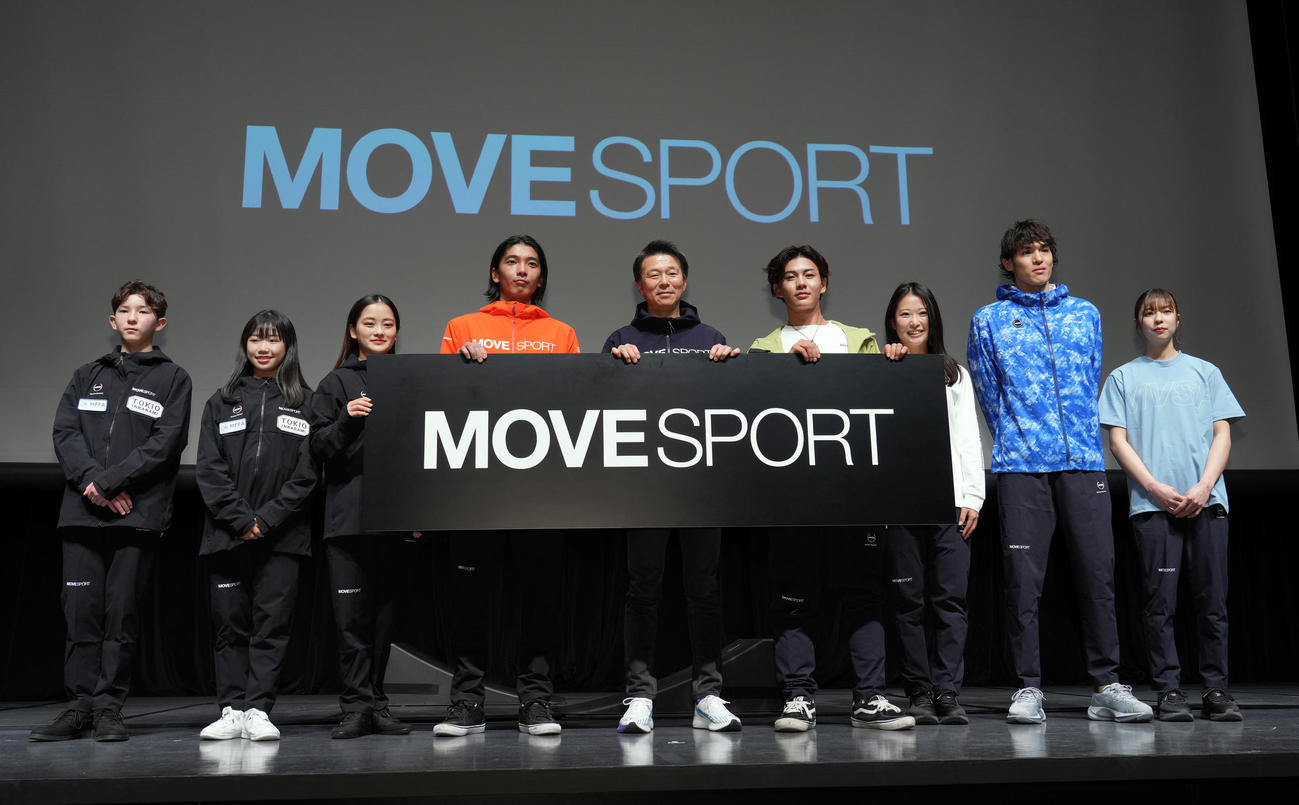 デサントのニューレーベル「MOVESPORT」の記者会見で記念撮影する、左から中田、中井、渡辺、芝田、小川社長、大和、早川、楢崎明、久米（撮影・狩俣裕三）