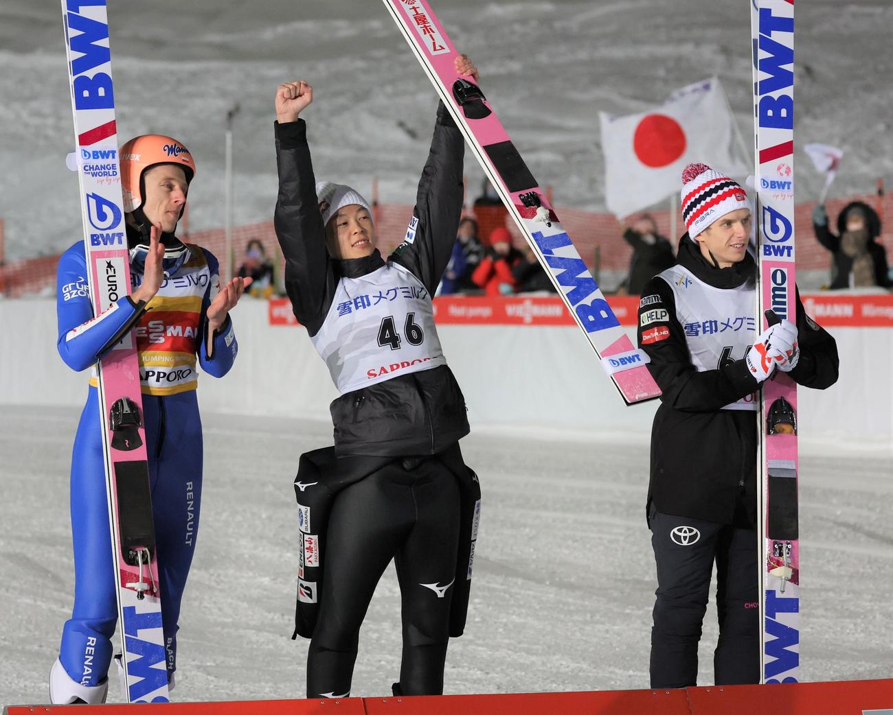 優勝しガッツポーズの小林陵侑（中央）。左は2位クバツキ、右は3位ハルボルエグネル（撮影・黒川智章）