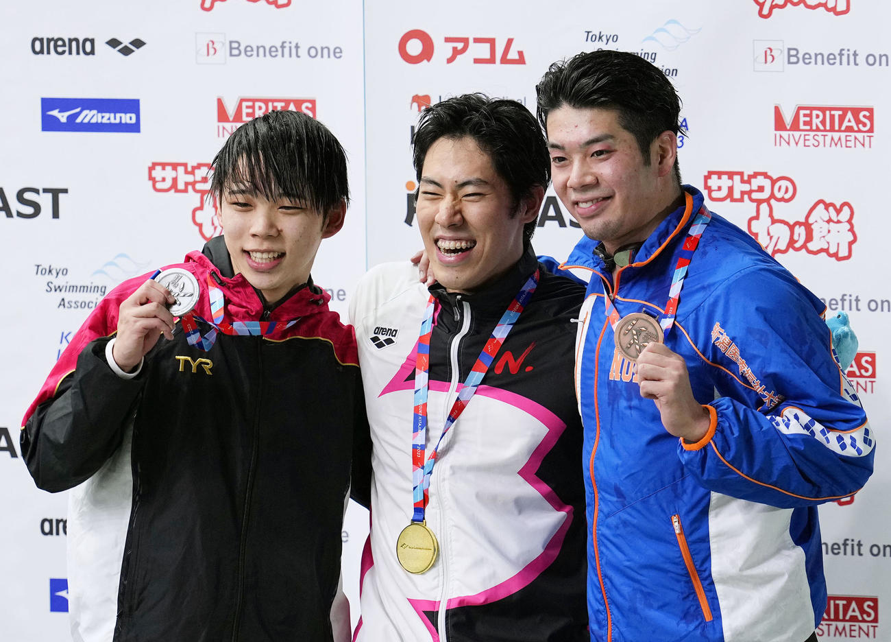 男子100メートル バタフライで優勝し、表彰式で笑顔の本多灯（中央）。右は3位の水沼尚輝（共同）