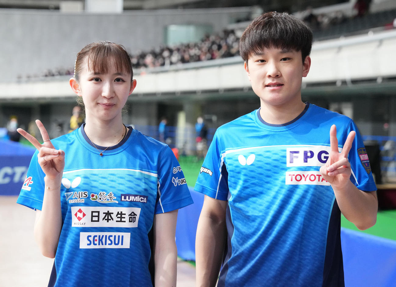 混合ダブルスで2連覇し、笑顔でピースする早田（左）、張本智組（撮影・鈴木みどり）