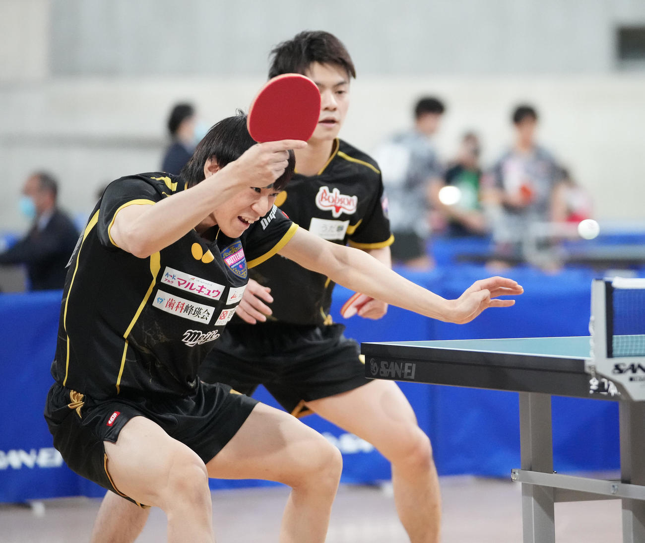 男子ダブルス5回戦の第2ゲーム、打ち返す戸上。奥は宇田（撮影・鈴木みどり）