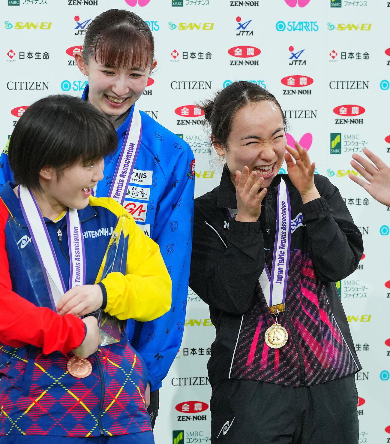 表彰式でなぜか優勝トロフィーを大藤（左）に持たせ笑顔を見せる伊藤（右）、早田（撮影・垰建太）