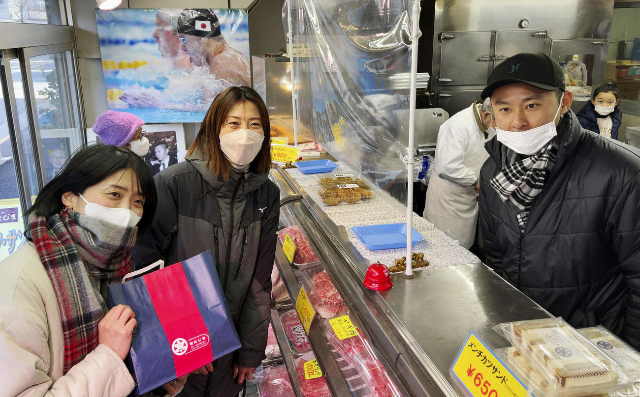 実家の精肉店を手伝う北島康介さん（右）と購入に訪れた（左から）中村礼子さん、寺川綾さん（共同）