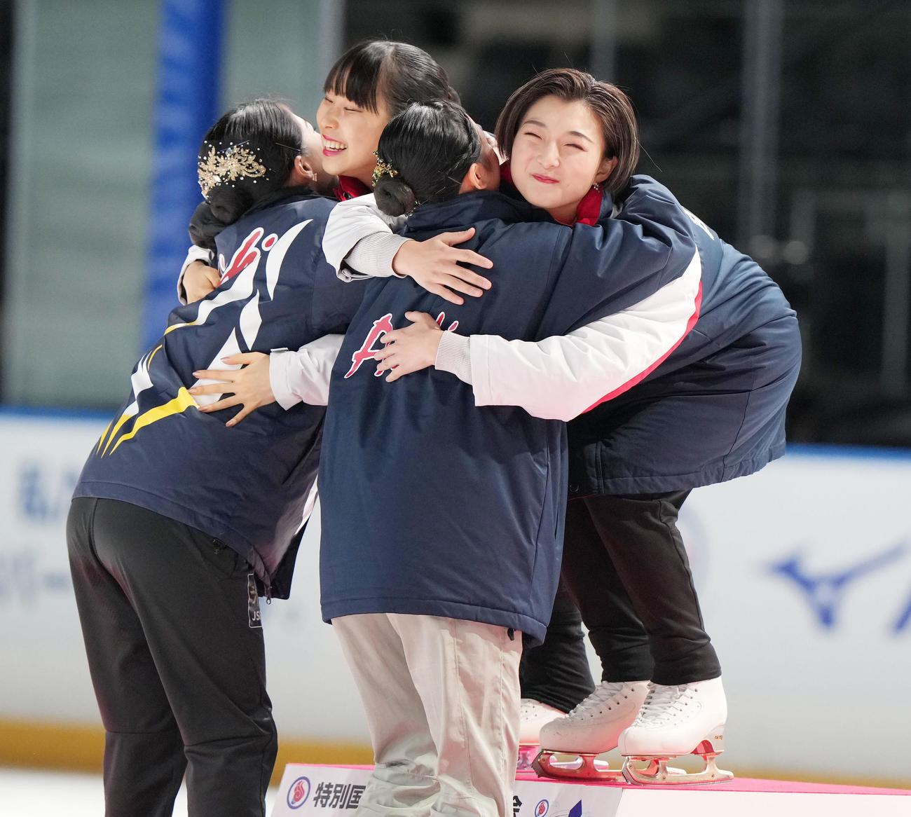 成年女子フィギュアスケートの表彰式で2位愛知の山下（手前右）をハグして迎える優勝した坂本（右）。後方左は三原、手前左は横井（撮影・狩俣裕三）