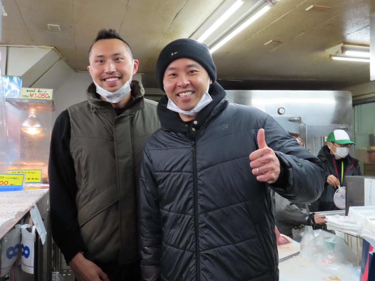 閉店する実家の精肉店「北島商店」で店頭に立つ北島康介さん（右）。左は駆け付けた後輩の塩浦慎理（撮影・近藤由美子）