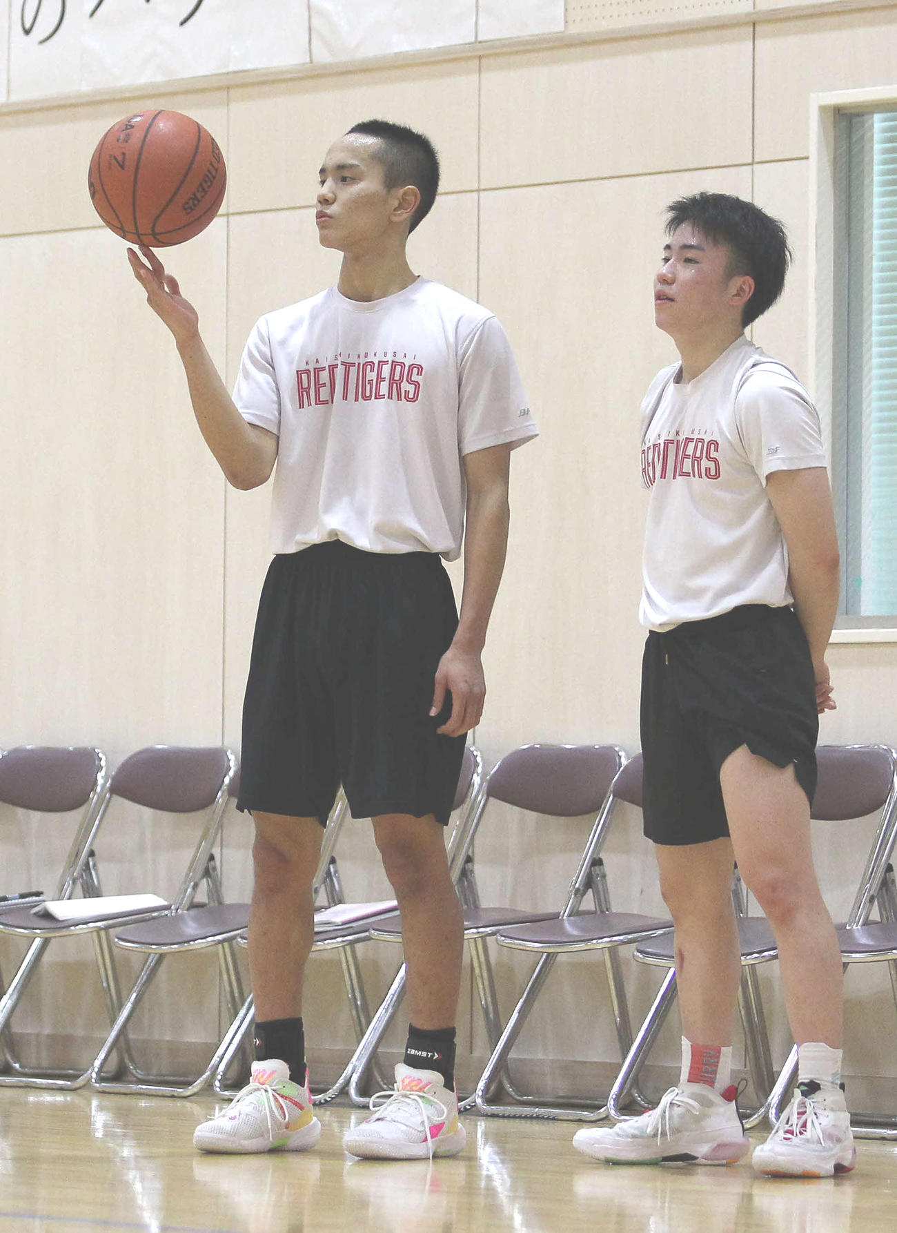 ボールを指で回しながら他選手の練習を見つめるSG平良。右はPG沢田